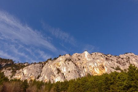 high rocky mountain wall with skywalk and blue sky in the springの写真素材