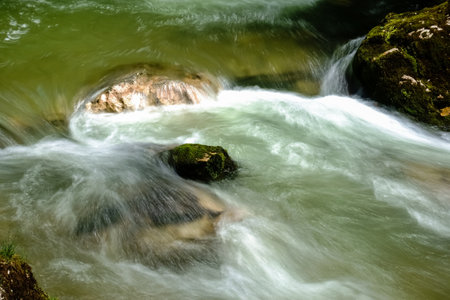 flowing soft water over rocks from a brook in the mountains detail viewの写真素材