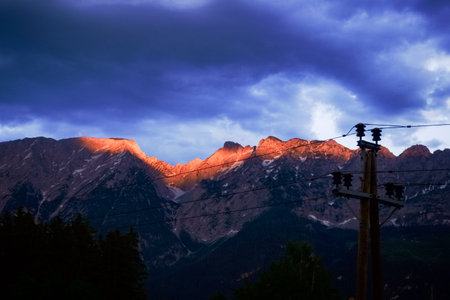 glowing mountain peaks in the sunset with rain clouds on vacation