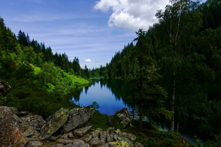 beautiful reflection in a blue mountain lake while hiking in the summerの写真素材