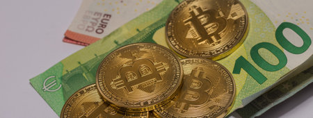 golden valuable bitcoins on euro bills panorama view