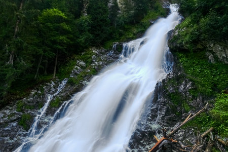 amazing white shining waterfall on vacation in austria mountains in the summerの写真素材