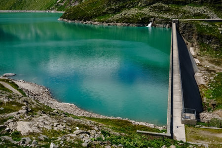 dam wall and wonderful green water from a water reservoir in the mountains in austriaの写真素材