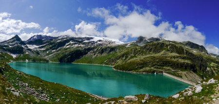 dam wall and wonderful green water from a water reservoir in the mountains panorama view