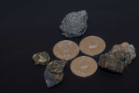 three silver ether coins from cryptocurrency and minerals with iron on black background
