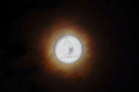 silver shining ehter coin on a dark sky with colorful sparkle