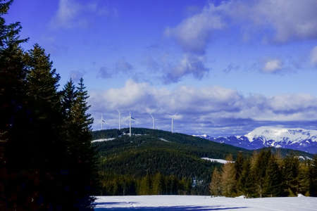 many wildmills on a mountain and blue sky with clouds in the winter