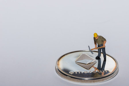 single miner standing on a single silver ether crypto currency with gray background