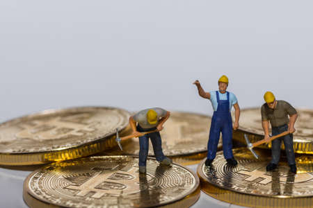 three miner working on gold shining bitcoins with gray background