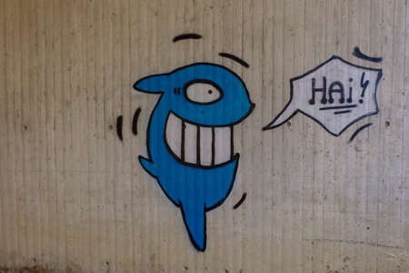 graffiti from a blue shark fish on a wall on a bridgeの写真素材