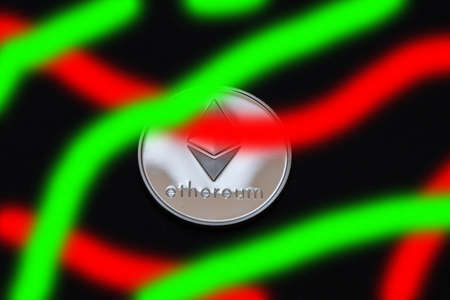 valueable shining silver ether coin from cryptocurrency on black with red and green stripesの写真素材