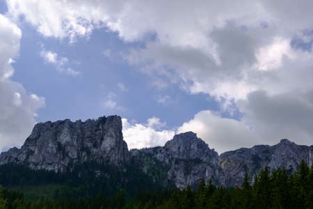 rugged mountains and white white clouds on the skyの写真素材