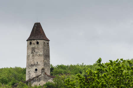 tower with windows and a roof on a green hill in the natureのeditorial素材