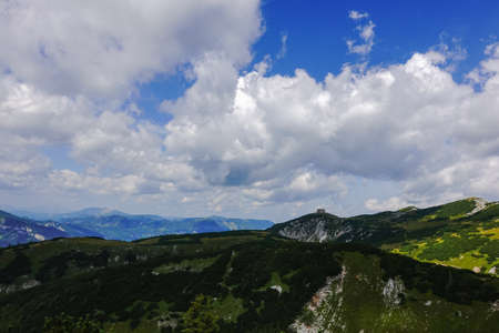 alpine hut in the distance on a summit in a mountain landscape while hikingの写真素材