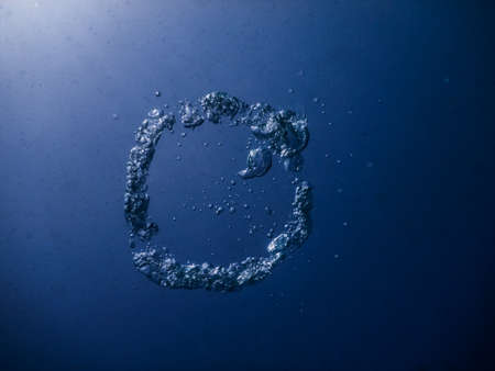 ring of bubbles while freediving in blue clear water from a lakeの写真素材