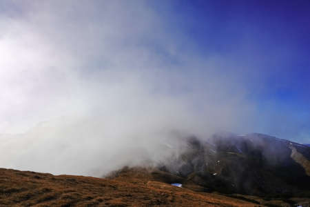 strong current from a fog from the valley on a mountain in austria