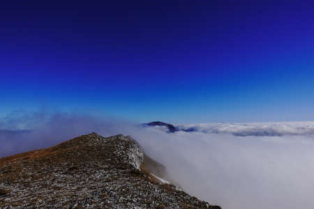 deep blue sky and dense fog while hiking to the top from a mountain while hiking