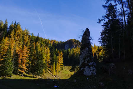 high peaky rock in a colorful landscape with a forest in autumnの写真素材