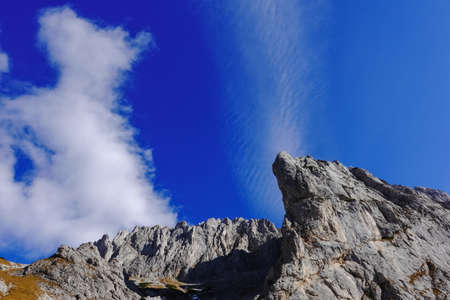 mountain range with wonderful peaks and current on the blue sky in styria austriaの写真素材