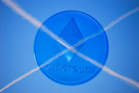 cross from contrails at the sky with a blue valueable ether coinの写真素材