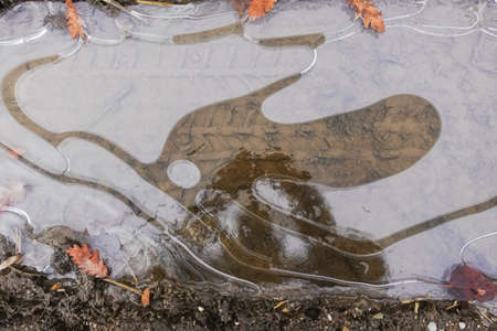frozen puddle with air pockets and kreative forms in the winter detail view