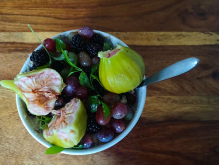 fresh tasty plate with different fruits on a wooden table and a spoon in the summer