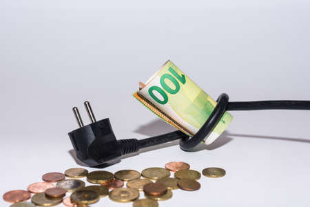 Energy prices increase and energy consumption power cable with knot and money with gray backgroundの写真素材