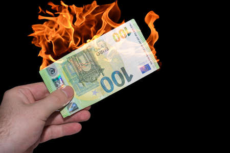 hand helding one burning euro bank note inflation in the world with black backgroundの写真素材