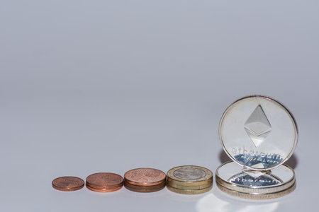 euro coins and ether coins from crypto currency stacked in a row with gray background view aboveの写真素材
