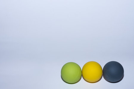 three different colored balls for massage in a row on gray background right viewの写真素材