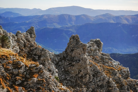 view through sharp rock into a valley with lot of other mountainsの写真素材