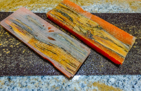 two colorful sanded pieces of wood with epoxy resin for a knife handle