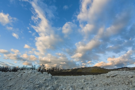 amazing clouds at the blue sky in a lime quarry before sundownの写真素材