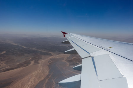 view to the wings from an airplane during a flight over the desert in egypt with blue skyの写真素材