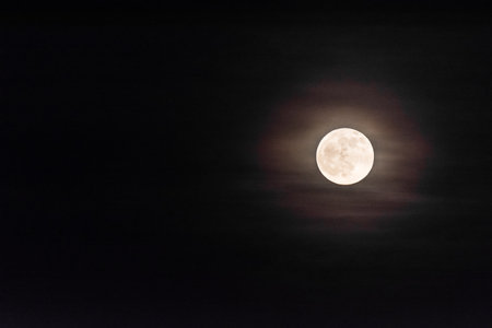 shining moon with colorful area around in dark nightの写真素材