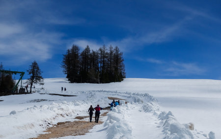 deep blue sky and lot of snow with hikers on a mountain in the springの写真素材