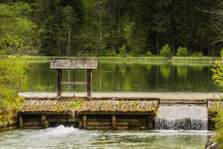 sluice on a pond with a wonderful landscape named schiederweiher in upper austriaの写真素材