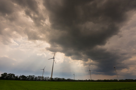 dense dark rain clouds and pinwheels on a fieldの写真素材