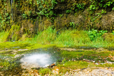 white atomized water from the water through overhanging conglomerate named rinnende mauer in upper austriaの写真素材
