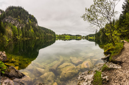 huge rocks in a mountain lake with wonderful reflections from the landscape panorama viewの写真素材