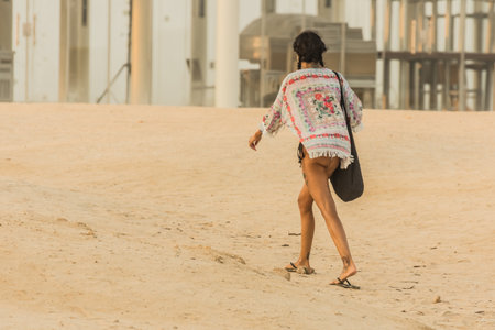 person walking in the sand near the beachの写真素材