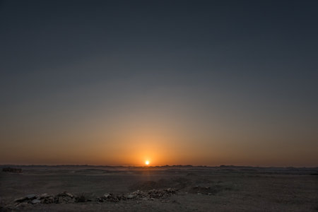 amazing warm sunset in the desert with mountains at the horizon on vacation in egyptの写真素材