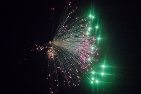 green and lilac fireworks from the side in the night on new years eveの写真素材