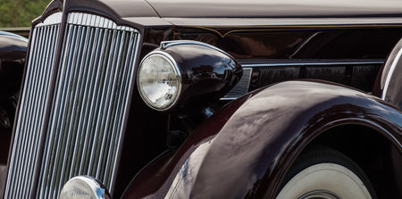 very old black classic car detail from front and lights panorama view