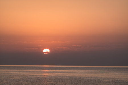 entwined sun with small clouds during sunrise at the red sea in egyptの写真素材