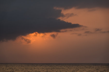 warm sun behind a dark cloud in the morning from egyptの写真素材