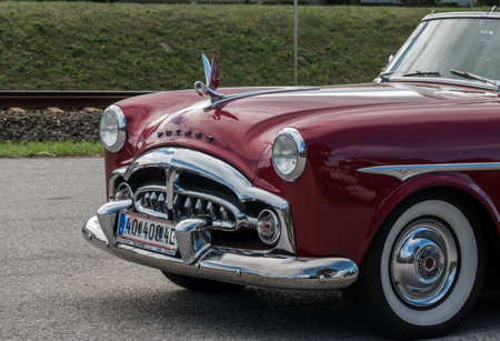 very old red classic car with a amazing hood ornament during a car showの写真素材