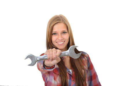 smiling young woman showing a wrench into the cameraの写真素材