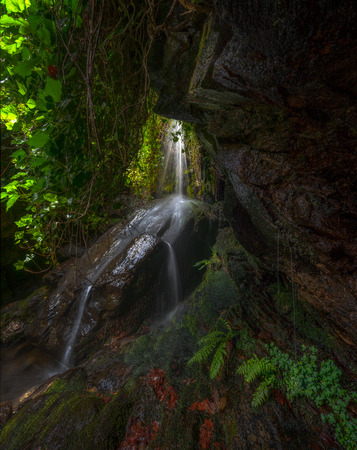 Waterfall seen through the opening of a cave, Spainの写真素材