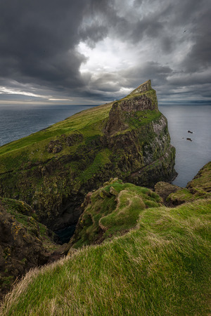View over the northern tip of the island of Mykines with it's white lighthouse in the distance, Faroe Islandsの写真素材